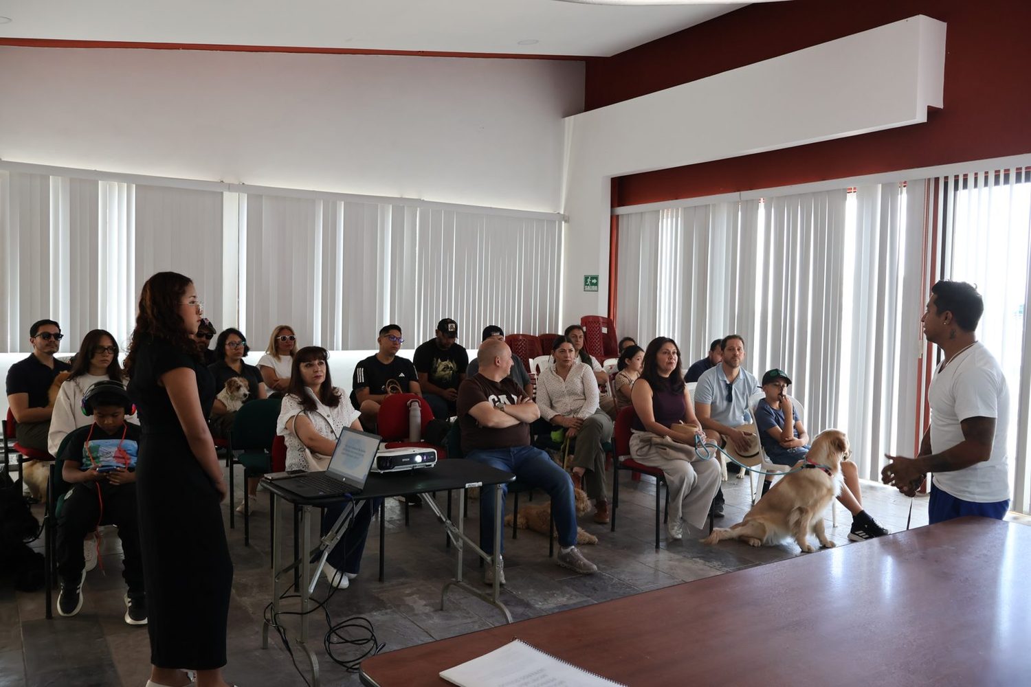 Instructor dirigiéndose a los asistentes en el salón